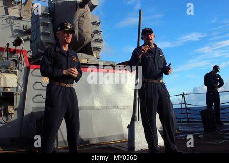 161226-N-WT 612-058 ATLANTIK (31. 26, 2016) Cmdr. Christopher J. Gilbertson von Minneapolis, kommandierender Offizier der geführten Anti-raketen-Zerstörer USS Mason (DDG87), rechts, stellt der Adm. Jim Malloy, Kommandeur der Carrier Strike Group 10, um die Crew während alles - Hände Anruf auf dem Achterdeck Raketen deck. Mason, eingesetzt als Teil der Eisenhower Carrier Strike Group, ist die Durchführung von naval Operations in den USA 6 Flotte Bereich der Maßnahmen zur Unterstützung der US-amerikanischen nationalen Sicherheitsinteressen in Europa. (U.S. Marine Foto von Petty Officer 2. Klasse Tahriqa Fareed) Stockfoto