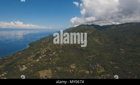 Luftbild Küste auf der tropischen Insel mit Blick auf das Meer, Bäume und Palmen. Erstaunlich schöne Landschaft der Natur mit Bergen, Hügeln, Wald regen. Marine: Meer und Himmel. Antenne Panoramablick auf Insel Küste. Philippinen, Cebu. Travel Concept. Stockfoto