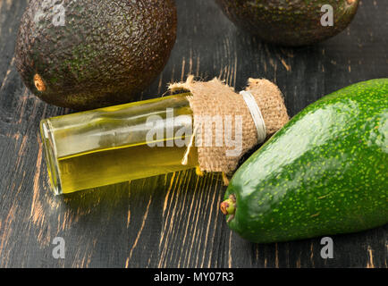 Avocado Öl in der Flasche mit Gemüse auf dem Tisch Stockfoto