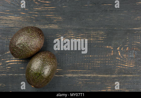 Zwei reife Avocados Hass auf eine leere Holz- Hintergrund der Ansicht von oben Stockfoto