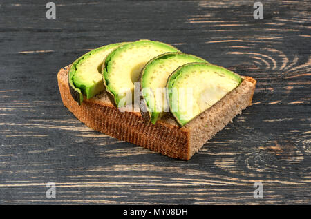 Sandwich mit Schichten von frischen Avocado auf hölzernen Hintergrund Stockfoto