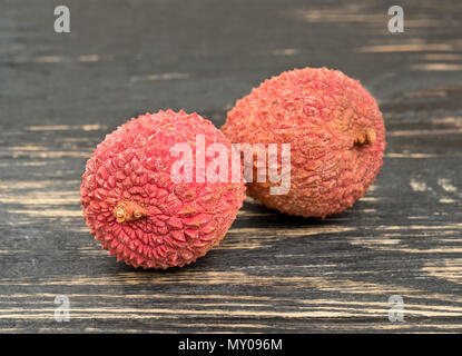 Zwei lychee Obst in der Schale closeup auf einem hölzernen Hintergrund Stockfoto