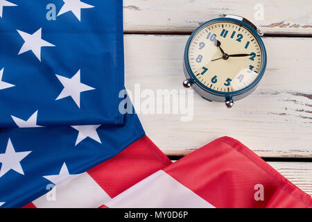 Close up USA-Flagge und Wecker. Mechanische Wecker und Flagge der Vereinigten Staaten auf hellen Hintergrund. Zeit zu stimmen. Stockfoto