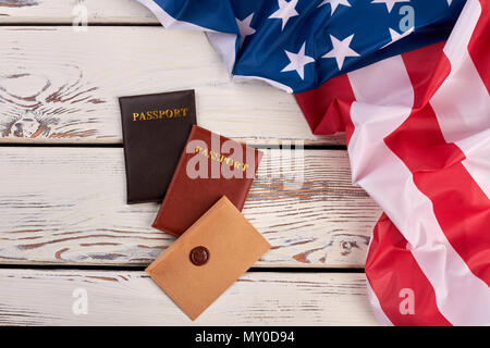 USA-Flagge, Pässe und Umschlag. Amerikanische Flagge und Dokumente auf vintage Holz- Hintergrund, Ansicht von oben. Stockfoto