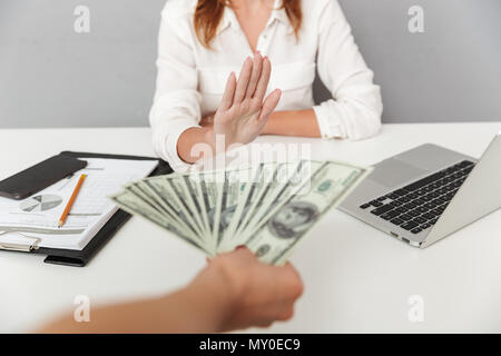 Close up Portrait von Hand mit Geld bestechen vor ein weiblicher Büroangestellter isoliert. Geschäftsfrau, Nein zu sagen Stockfoto