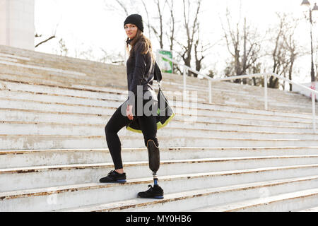 Foto der kaukasischen behinderte Frau in Sportswear mit Beinprothese zu Fuß die Treppe im Freien Stockfoto