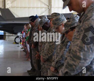 Flieger der 56th Fighter Wing Bogen ihre Köpfe während einer Anrufung bei der 56 Comptroller Squadron Ändern des Befehls Zeremonie Mai 30, 2018 Luke Air Force Base, Ariz. lt Col Joseph Nicholas aufgegeben Befehl an Maj Sean James. (U.S. Air Force Foto von Airman 1st Class Aspen Reid) Stockfoto