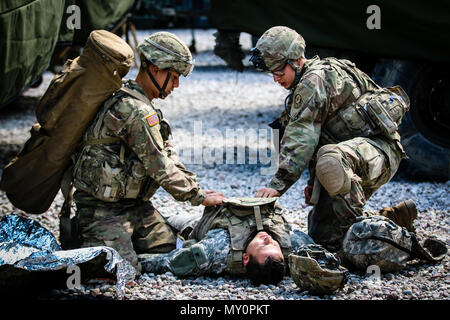 Pfc. Yadiel Römischen (links), Buffalo, New York Native, infanteristen mit 1St Squadron, 2.Kavallerie Regiments, und Pfc. Maynor Discua (rechts), Woodbridge, Virginia Eingeborener, mit infanterist 1. Staffel, 2. Reiterregiment, Bekämpfung der Unfall um einen anderen Soldaten während des Kampfes Lebensretter Training mit Battle Group Polen Bemowo Piskie, Polen, 31. Mai 2018. Battle Group Polen ist ein einzigartiges, multinationale Koalition von USA, Großbritannien, Kroatischen und rumänischen Soldaten, die mit der polnischen 15 mechanisierte Brigade als Abschreckung Kraft zur Unterstützung des NATO-Enhanced vorwärts Präsenz dienen Stockfoto