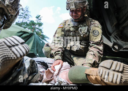 Pfc. Yadiel Roman, Buffalo, New York Native, infanterist, mit der 1. Staffel, 2. Kavallerie Regiments, gilt Dressing während des Kampfes Lebensretter Training mit Battle Group Polen Bemowo Piskie, Polen, 31. Mai 2018. Battle Group Polen ist ein einzigartiges, multinationale Koalition von USA, Großbritannien, Kroatischen und rumänischen Soldaten, die mit der polnischen 15 mechanisierte Brigade als Abschreckung Kraft zur Unterstützung des NATO-Enhanced vorwärts Präsenz dienen. (U.S. Armee Foto von SPC. Hubert D. Delany III) Stockfoto