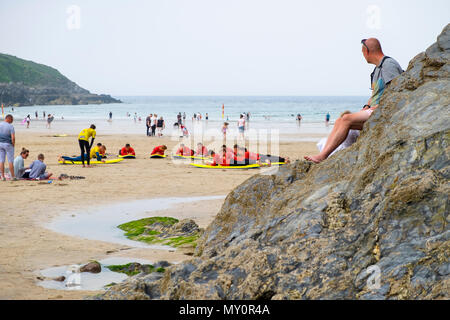 Ein Mann sieht sich als Surf Schule Unterricht findet auf den Fistral Beach, Newquay, Großbritannien Stockfoto