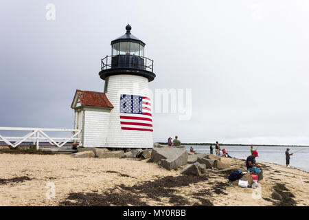 Nantucket, Massachusetts. Brant Point Light, ein Leuchtturm am Hafen von Nantucket Island gelegen, mit mehreren Personen angeln und eine amerikanische Flagge Stockfoto