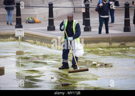 London, UK, 5. Juni 2018, ein Mann fegt und putzt die leere Brunnen am Trafalgar Square auf einer langweiligen, grauen und kalten typischer Tag Sommer, die Prognose für die Verbesserung und wärmeres Wetter als die Woche geht weiter. Credit: Keith Larby/Alamy leben Nachrichten Stockfoto