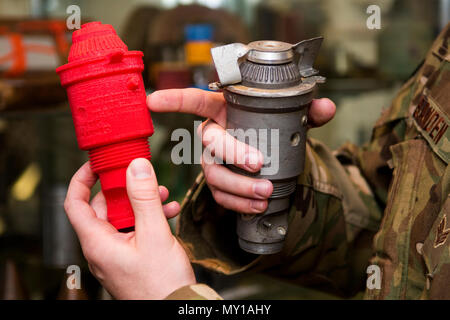 Senior Airman Nathanael Banden-industrie, 4. Bauingenieur Squadron die Beseitigung von Explosivstoffen Techniker, vergleicht eine M904 Bombe Nase Fuze auf seine 3D-gedruckten Gegenstück, Dez. 14, 2016, bei Seymour Johnson Air Force Base, North Carolina. Mit der Fähigkeit, um den Einsatz der kostengünstigen Kunststoffen produzieren, EOD-Techniker können schneiden, Scheren, Punktion oder komplett ein Training Munition voll eine Übung ohne finanzielle Auswirkungen vollständig auslöschen. (U.S. Air Force Foto von Airman Shawna L. Keyes) Stockfoto