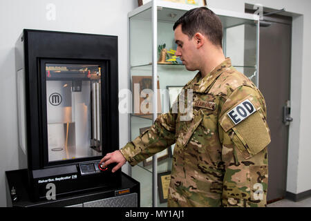 Senior Airman Nathanael Banden-industrie, 4. Bauingenieur Squadron die Beseitigung von Explosivstoffen Techniker, Kontrollen auf dem 3D-Drucker als es eine Ausbildungshilfe druckt, Dez. 14, 2016, bei Seymour Johnson Air Force Base, North Carolina. Druckaufträge können überall von 10 bis mehr als 48 Stunden, abhängig von der Größe und Komplexität der Ausbildungsbeihilfen. (U.S. Air Force Foto von Airman Shawna L. Keyes) Stockfoto