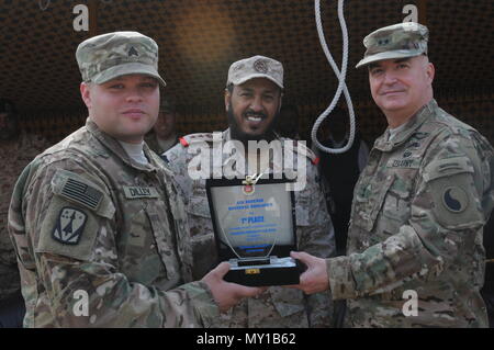 161229-PA 067-010 Sgt. Brian Dilley, einem truppführer mit der 69Th Air Defense Artillery Brigade, nimmt den ersten Platz Preis im Namen seiner Einheit von Major General Blake Ortner, Kommandant der 29 Infanterie Division und Oberst Jabar Al-boti des kuwaitischen Air Defence Force während der Patriot Tag Aktivitäten auf Kuwait Air Defence Force Headquarters in Kuwait 28. Dezember 2016. Der Wettbewerb zwischen den Kuwaitis und die 69 ADA enthalten Ereignisse wie z. B. Einrichten einer MIM-104 Patriot-Waffensystem, ein Fußball-Spiel, und Tauziehen. (Foto von der U.S. Army Sgt. Kelly R. Gary.) Stockfoto