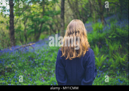 Eine junge Frau steht auf einer Wiese der bluebells Stockfoto