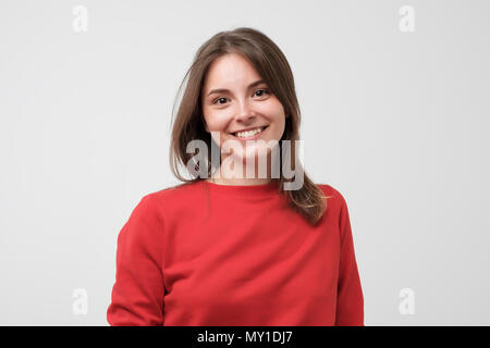 Porträt der jungen schönen gcaucasian Frau in Rot t-shirt cheerfuly Lächeln auf die Kamera schaut. Stockfoto