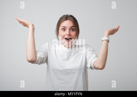 Hübsche junge europäische Frau im weißen T-Shirt ist aufgeregt und glücklich zu gut kennen. Stockfoto