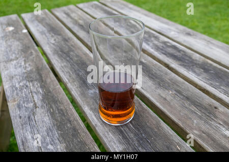 Halb voll Pint Adnams bitter auf einem pub Tabelle. Übersicht Glas halb voll oder halb leer ist. Suffolk, Großbritannien. Stockfoto