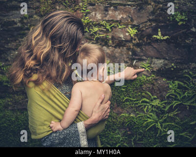 Eine Mutter ihr Baby ein oder zwei Dinge über Pflanzen, die an den Wänden von an ihn gerichtet Stockfoto