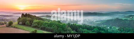 Lebendige Panoramablick Sonnenaufgang über Landschaft Hügel in Polen. Frühling Nebel und grüne Felder. Stockfoto