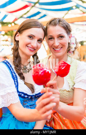 Freunde in einem Bierzelt Holding candy Äpfel Stockfoto