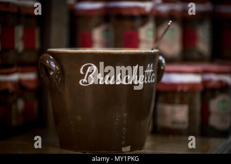Große braune Schale steht auf einem Holztisch, viele kleine Gläser im Hintergrund Stockfoto