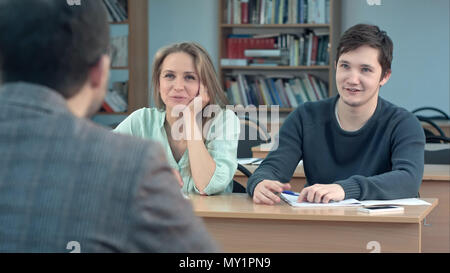 Studenten aufmerksam zuhören auf männliche Lehrer und Kommunikation im Klassenzimmer Stockfoto