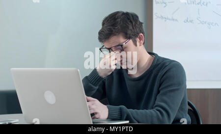 Müde Schüler in der Nähe von Notebook schlafen in der Schule Stockfoto