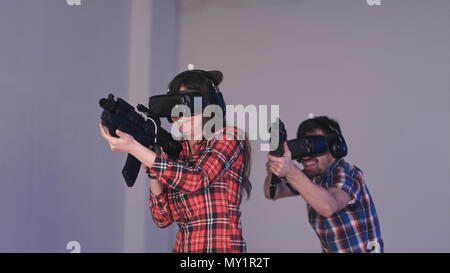 Freunden, die VR-shooter spiel mit virtueller Realität Gewehren und Gläser Stockfoto