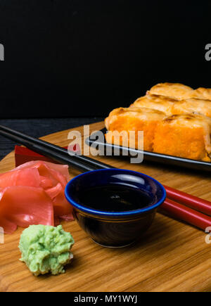 Heißes gebratenes Sushi Roll mit Lachs, Kaviar, Garnelen, Gurke, Avokado, Käse. Sushi Menü. Japanisches Essen mit Wasabi, Ingwer, soy souce. Heißes gebratenes Sushi Stockfoto