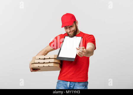 Lieferung Konzept: Junge hübsche Delivery Man mit pizza Kartons geben Ihnen ein Dokument signieren Stockfoto