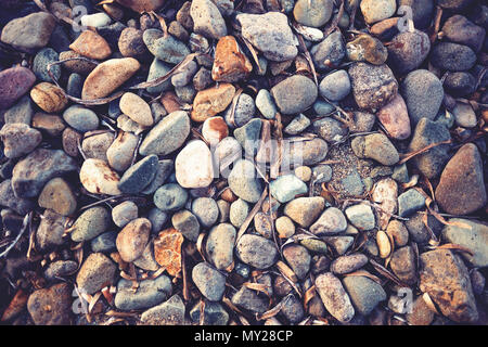 Bunte Kieselsteine am Strand. Ansicht von oben, Vintage Retro Look. Stockfoto