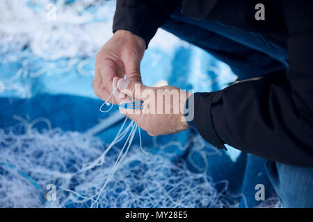Fischer zur Festsetzung einem Fischernetz mit einer Nadel Stockfoto