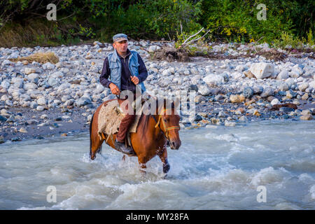 Adishi, Georgien - September 6, 2017: Mann vorbei Fluss durch das Pferd; Swanetien Berge Stockfoto