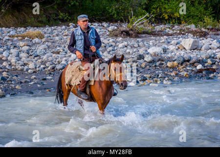 Adishi, Georgien - September 6, 2017: Mann vorbei Fluss durch das Pferd; Swanetien Berge Stockfoto