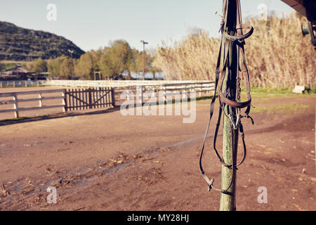 Vintage Leder Pferd Zügel hängen von der hölzernen Stange eines ländlichen Horse Farm. Stockfoto
