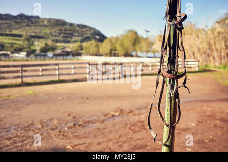 Jahrgang Pferd Halfter hängen von den Holz- Pol eines Western Horse Farm. Nähe zu sehen. Stockfoto