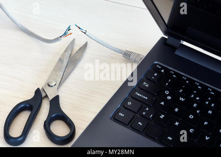 Kabel Internet auf einen Laptop mit einer Schere schneiden verbunden. Konzept der Internet verbot, cencorship und Unterbrechung. Stockfoto