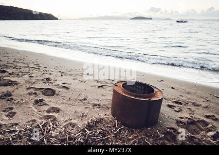 Rostige Waschmaschine Whirlpool am Strand, die die Verschmutzung der Umwelt durch industrielle Abfälle Stockfoto