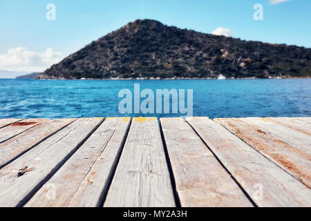 Leeren alten hölzernen Planken eines Hafen, Meer, Insel und blauer Himmel an einem sonnigen Tag in Bodrum Gumusluk Türkei Stockfoto