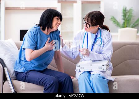 Junger Arzt besuchen alte reife Frau für Check-up Stockfoto