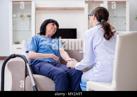 Junger Arzt besuchen alte reife Frau für Check-up Stockfoto