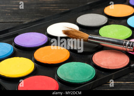 Palette mit Farben und Pinsel, Nahaufnahme auf dem Tisch Stockfoto