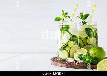 Zwei Gläser von Obst und Kräuter infundiert Wasser mit Gurke, Limette und Minze und Eiswürfel auf weißem Hintergrund. Das Konzept der Entschlackung und Gewichtsabnahme. Kopieren Sie sp Stockfoto