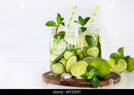 Zwei Gläser von Obst und Kräuter infundiert Wasser mit Gurke, Limette und Minze und Eiswürfel auf weißem Hintergrund. Das Konzept der Entschlackung und Gewichtsabnahme. Kopieren Sie sp Stockfoto