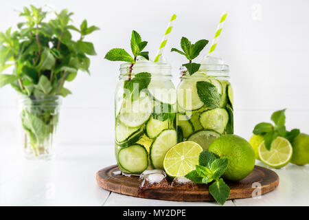 Zwei Gläser von Obst und Kräuter infundiert Wasser mit Gurke, Limette und Minze und Eiswürfel auf weißem Hintergrund. Das Konzept der Entschlackung und Gewichtsabnahme. Stockfoto