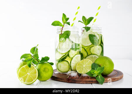 Zwei Gläser von Obst und Kräuter infundiert Wasser mit Gurke, Limette und Minze und Eiswürfel auf weißem Hintergrund. Das Konzept der Entschlackung und Gewichtsabnahme. Kopieren Sie sp Stockfoto