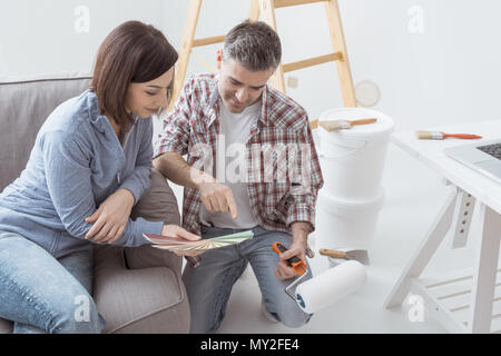 Home Renovierung und Dekoration: paar Auswahl der Farben für Ihr Haus Wände, Leiter und Farbeimer auf dem Hintergrund Stockfoto