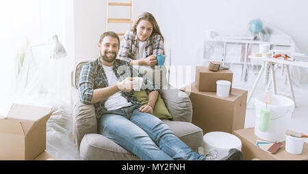 Paar entspannen während Home Renovierung, Sie sitzen auf einem Sessel und einer Kaffeepause Stockfoto